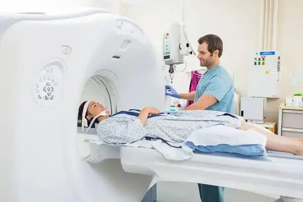 在医院中,一名技术人员正在为病人准备进行磁共振成像(MRI)扫描,用于精确分析身体成分。
